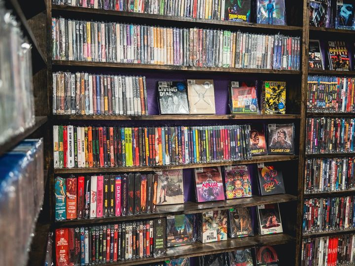A wall of shelves at Austin Video Store, packed with VHS, DVD and Blu-ray, cult and horror titles faced out